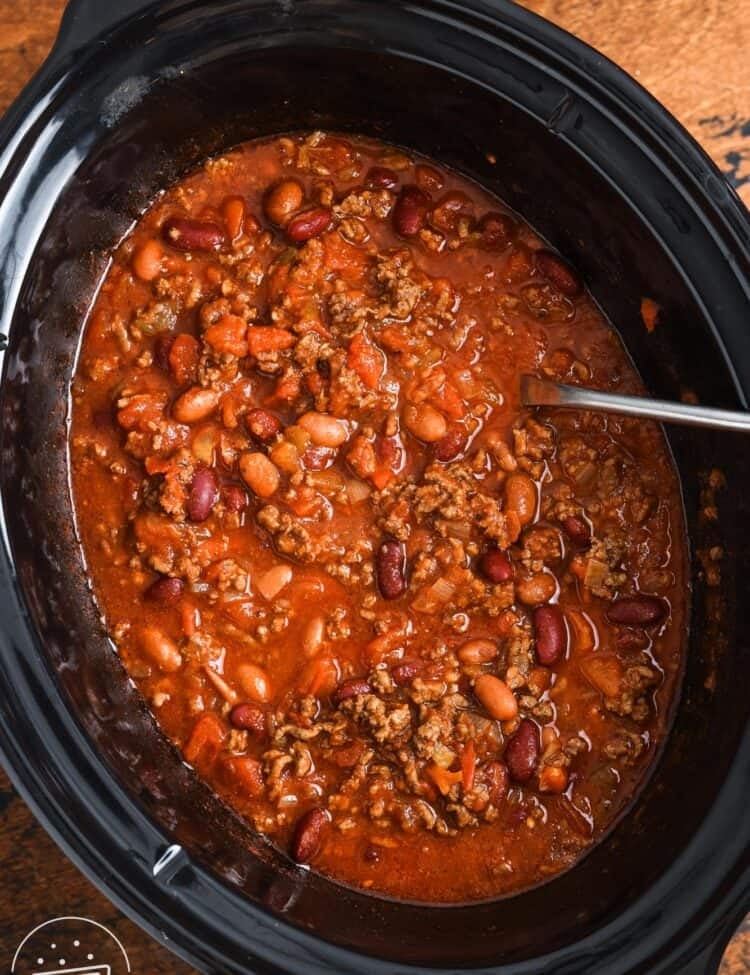 overhead view of beef chili in a black oval crockpot.