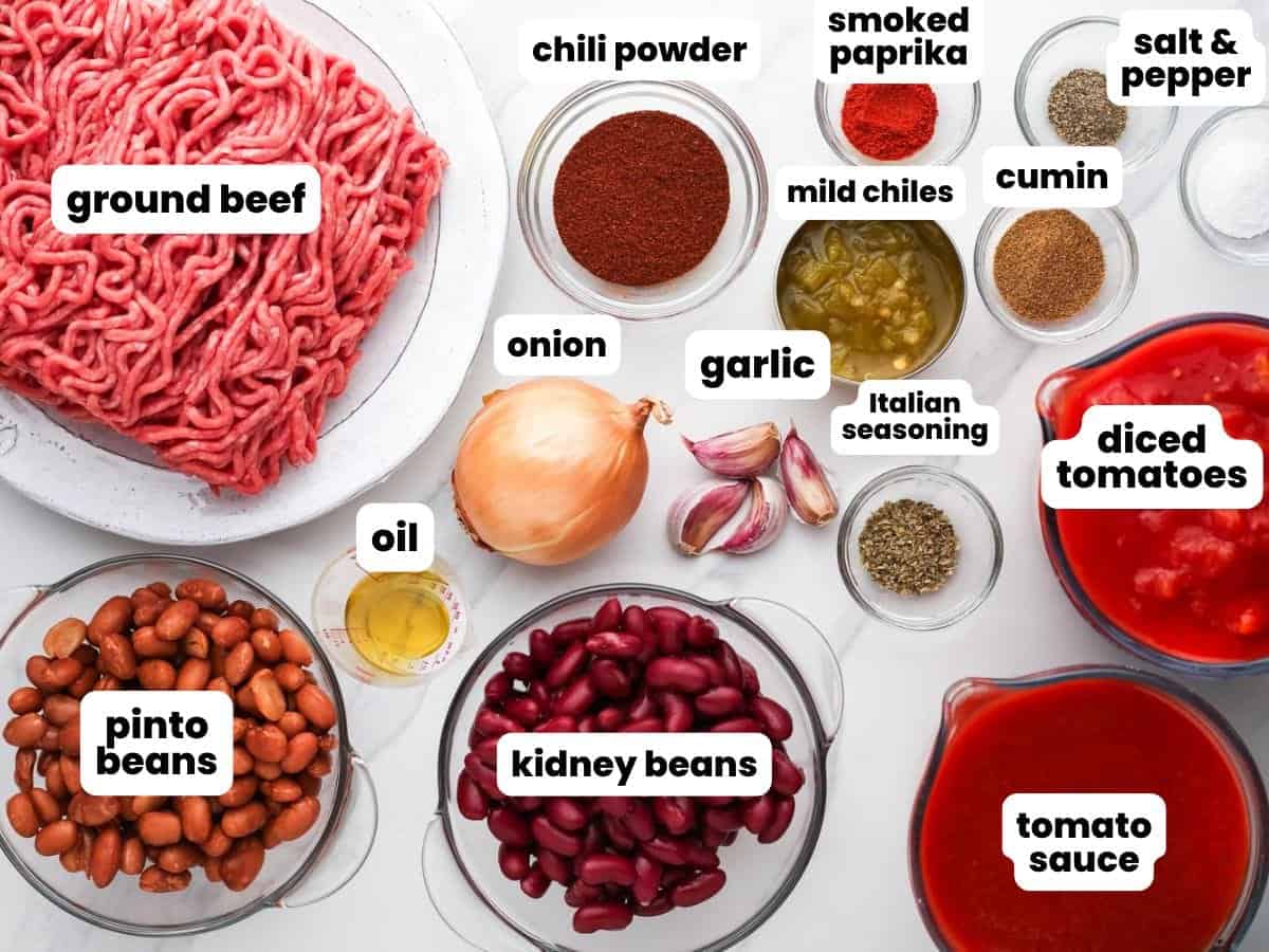 Ingredients for making beef chili in the crock pot, including two types of beans, canned tomatoes, seasonings.