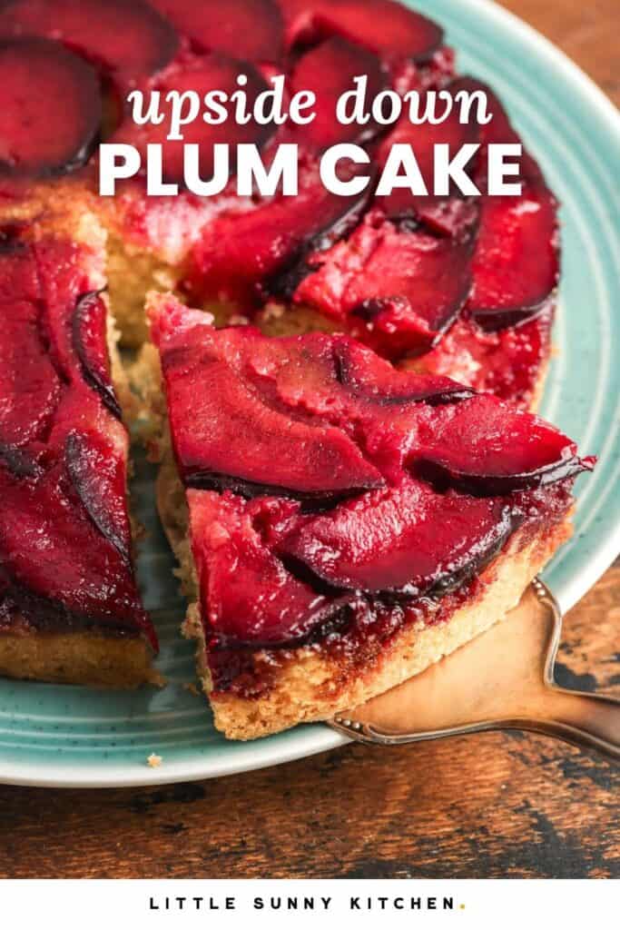 A slice of plum upside down cake being lifted from a teal plate, showing caramelized red plum slices on top of a soft vanilla cake.