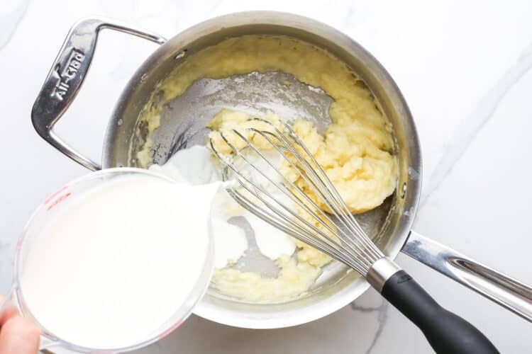 whole milk added to a light roux in a metal saucepan