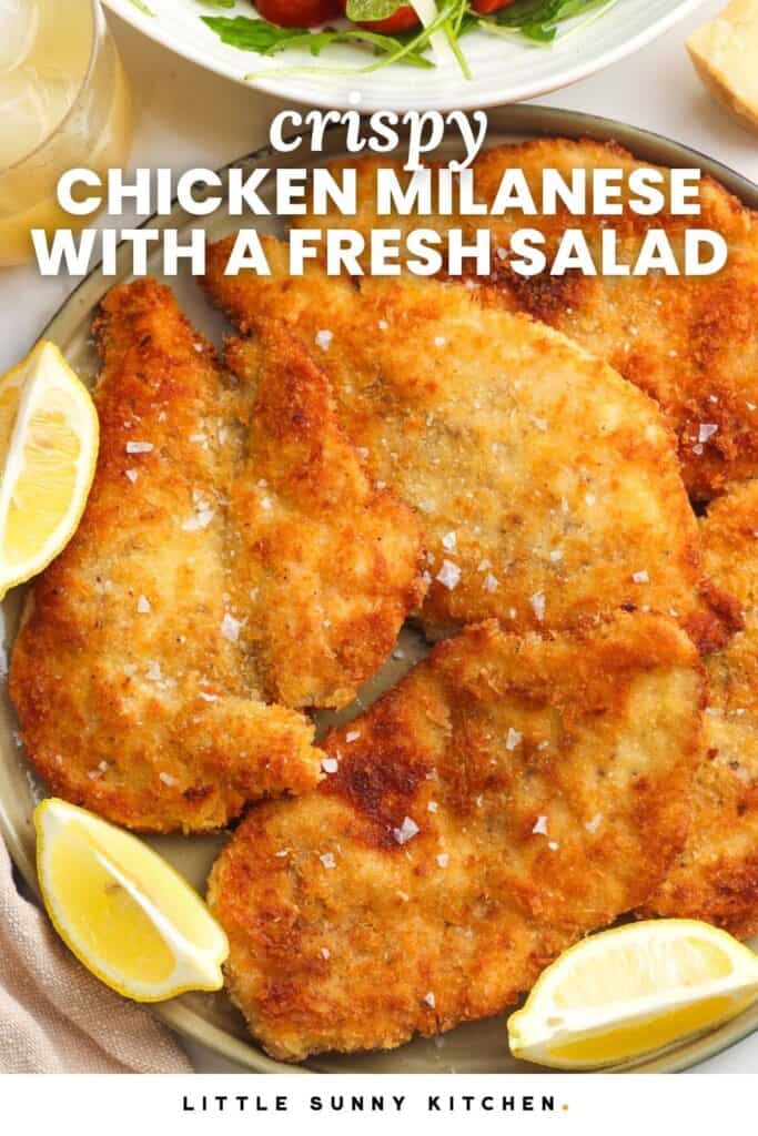 crispy chicken cutlets on a plate with lemon wedges. Text overlay says "crispy chicken milanese with a fresh salad"