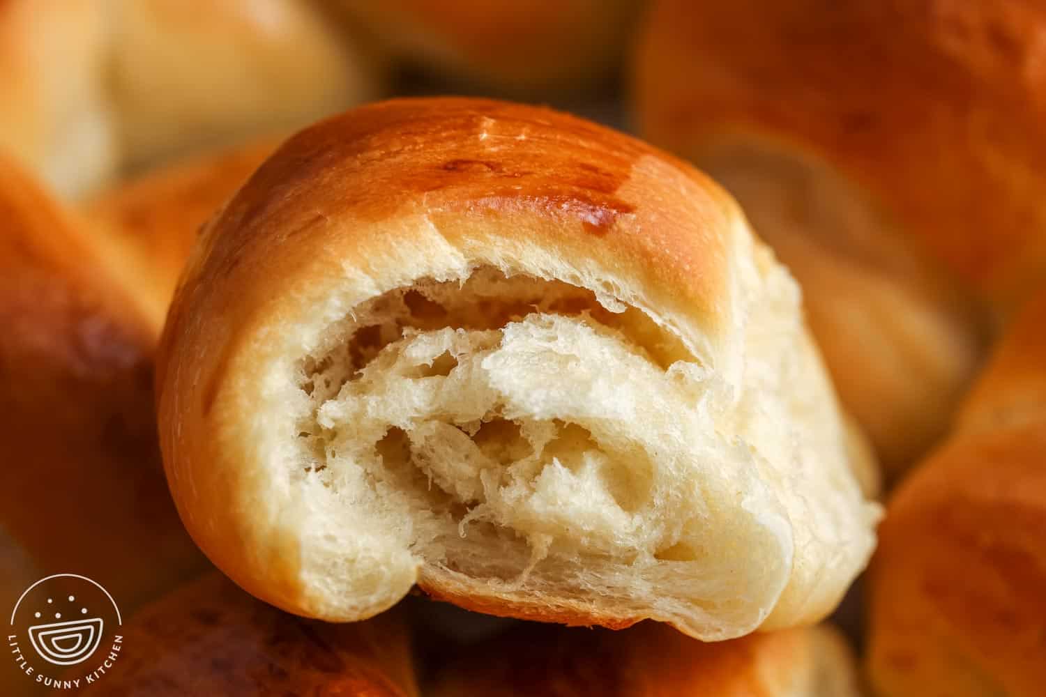closeup of the inside of a homemade crescent roll, showing the airy layers inside.