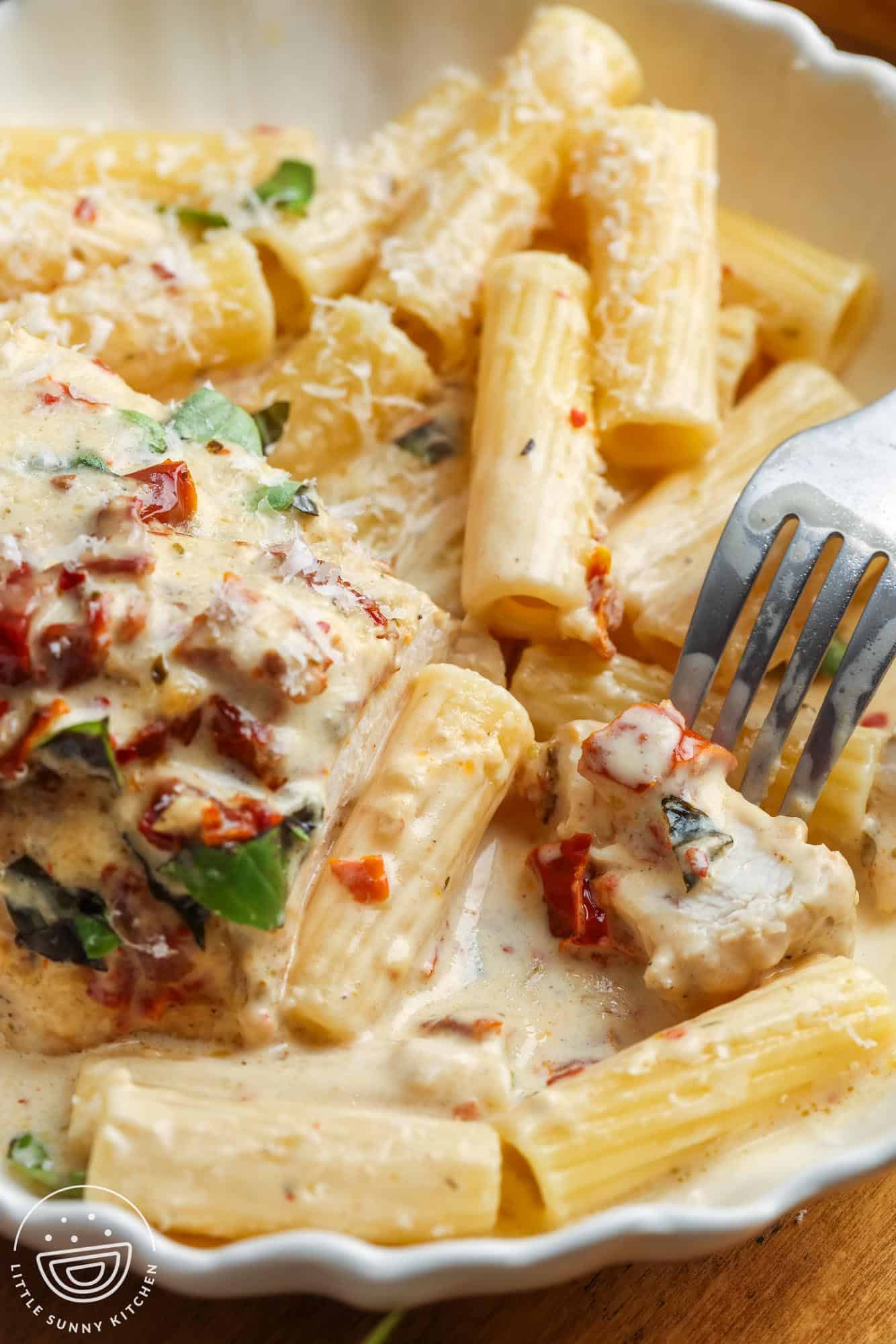 closeup of a plate of pasta with crockpot marry me chicken, showing the tender texture of the meat.