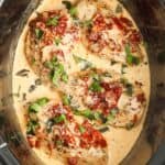 four chicken breasts in a creamy sauce, in a slow cooker. Topped with sundried tomatoes and fresh basil.