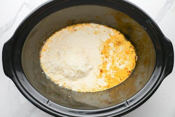 parmesan cheese and cream added to juices in the crockpot to make marry me chicken sauce.