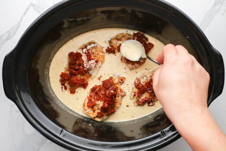 cooked chicken added to a creamy mary me chicken sauce in a crockpot.