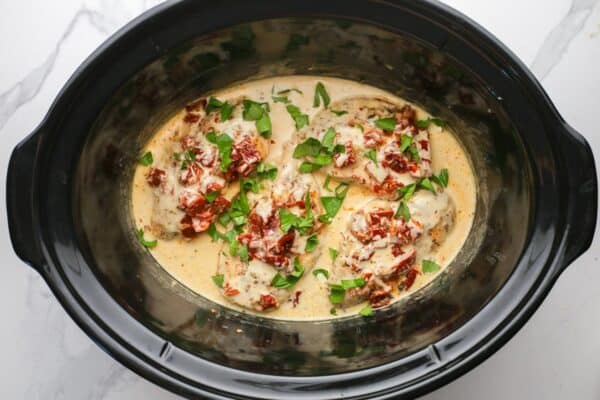crockpot marry me chicken, garnished with fresh chopped basil.