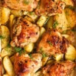 overhead view of a baking dish filled with lemon potatoes and crispy chicken thighs.