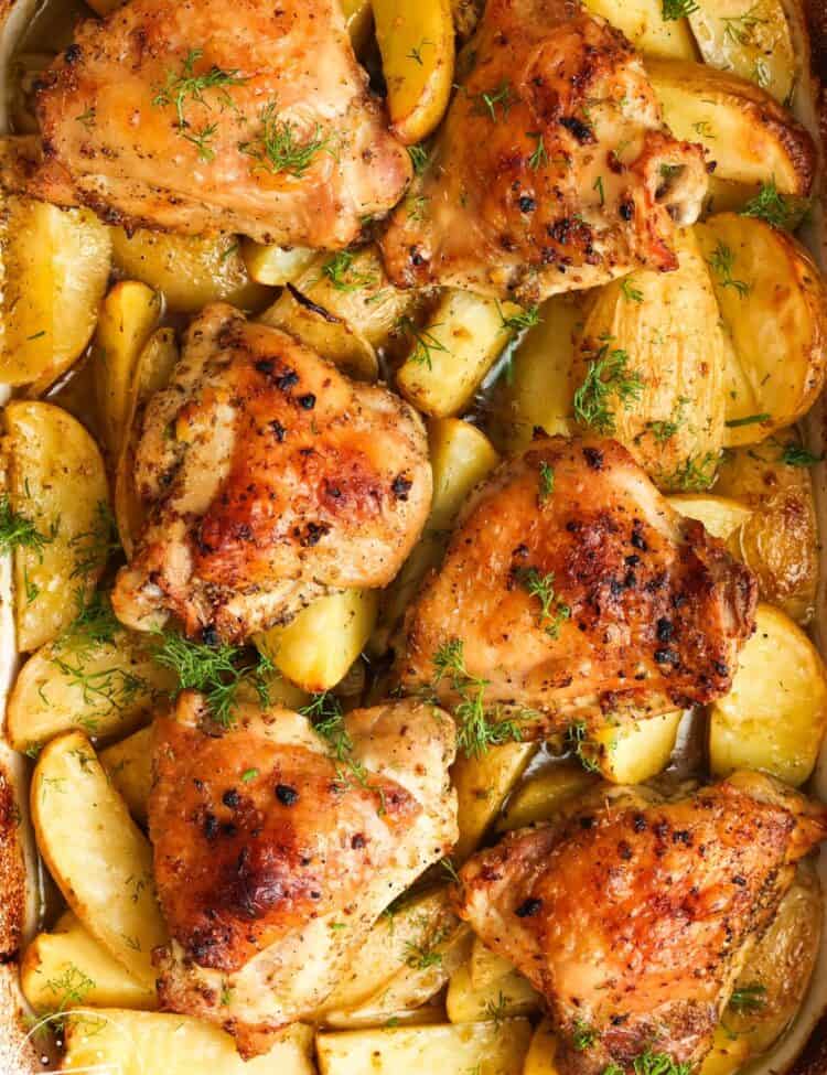 overhead view of a baking dish filled with lemon potatoes and crispy chicken thighs.