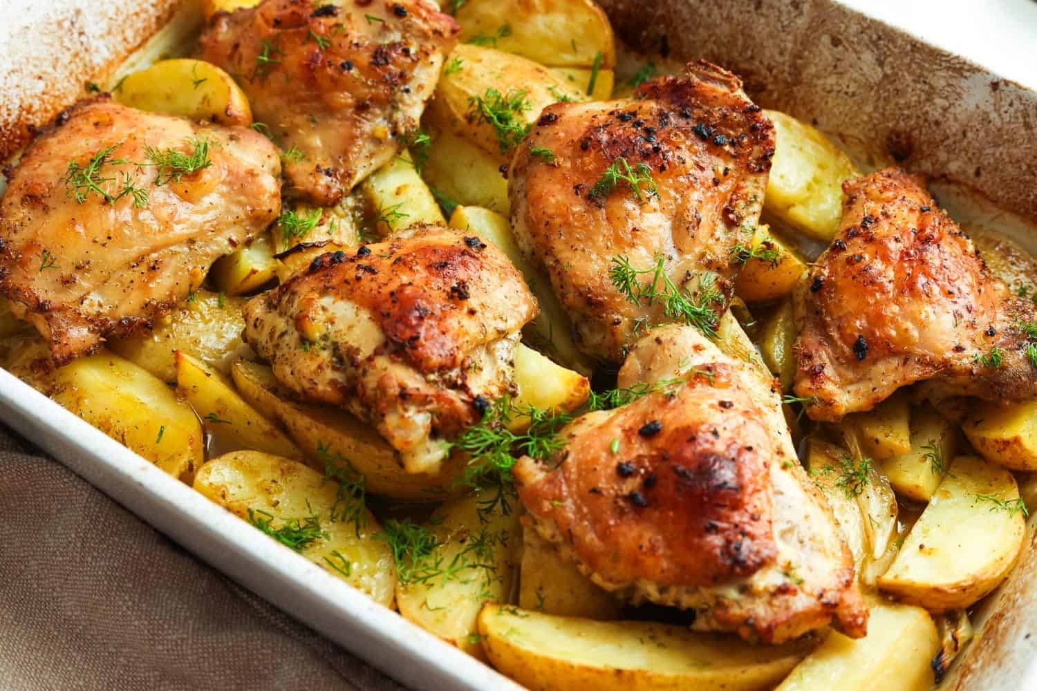 baked greek chicken and lemon potatoes in a baking dish