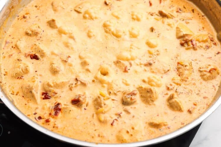 cream added to marry me chicken orzo in a skillet.