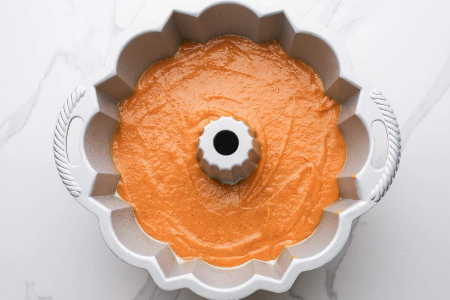 Bundt pan filled with pumpkin batter, ready to bake.