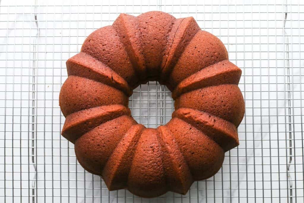Pumpkin bundt cake cooling on a wire rack.
