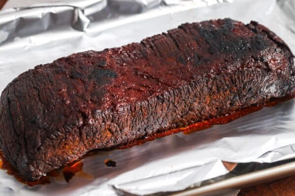 slow cooker brisket resting on a piece of foil.