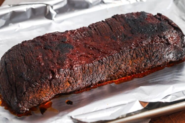 slow cooker brisket resting on a piece of foil.