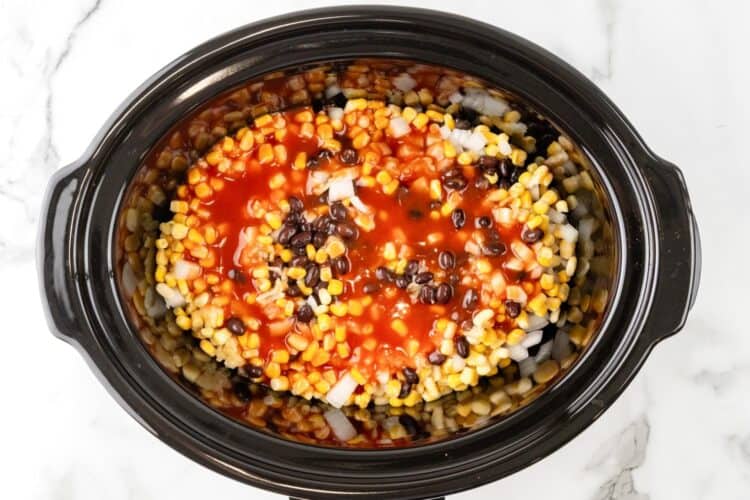 corn, black beans, and onions in a slow cooker with enchilada sauce.