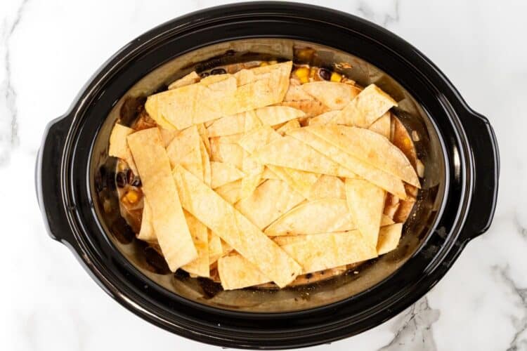 corn tortilla strips added over chicken enchilada casserole in the slow cooker.