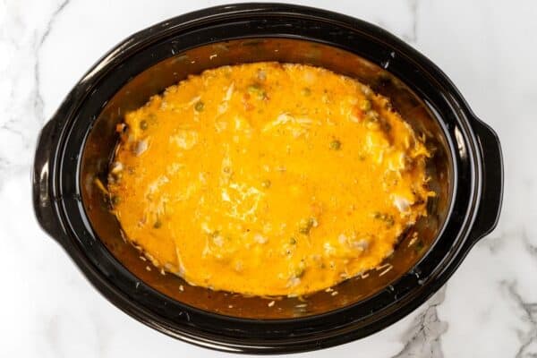 melted cheese over chicken rice casserole in a crock pot.