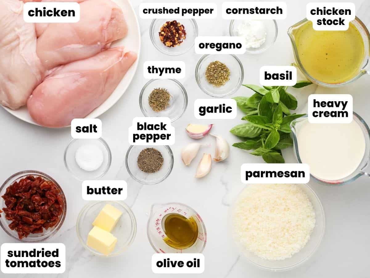 Ingredients for marry me chicken in the crockpot, including chicken breasts, heavy cream, sundried tomatoes, parmesan cheese, and garlic.