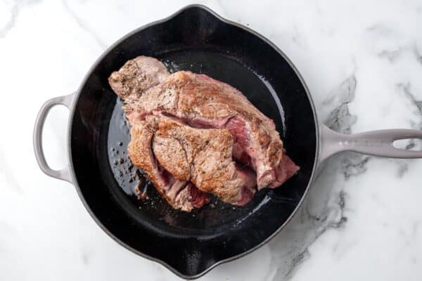 chuck roast seared in a cast iron skillet.