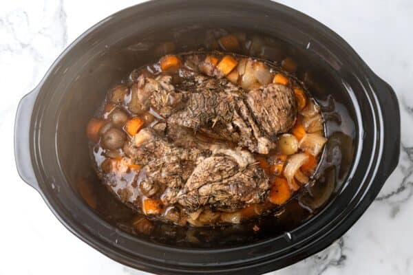 cooked slow cooker pot roast viewed from overhead.