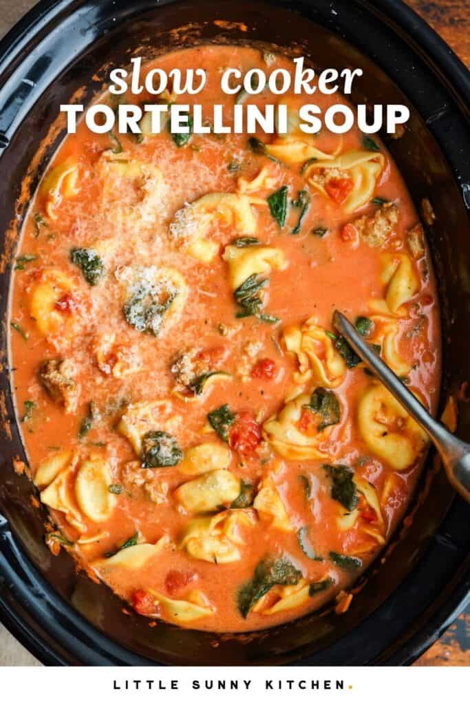 creamy tortellini soup with spinach and tomatoes in a slow cooker. Text overlay says "slow cooker tortellini soup"