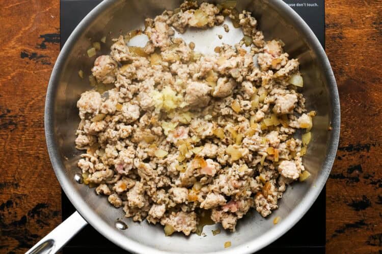 ground chicken cooking in a skillet, viewed from overhead.
