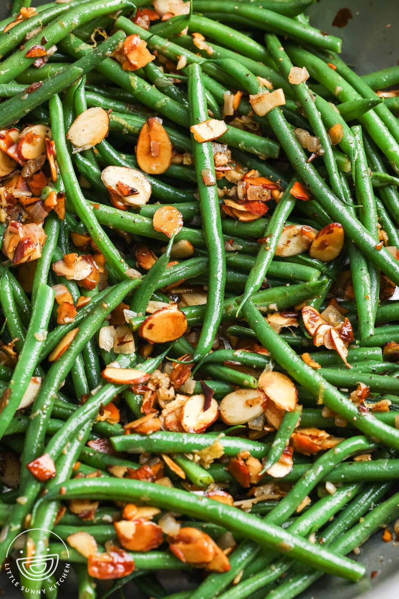 closeup of green beans with toasted almonds, aka green bean almondine.