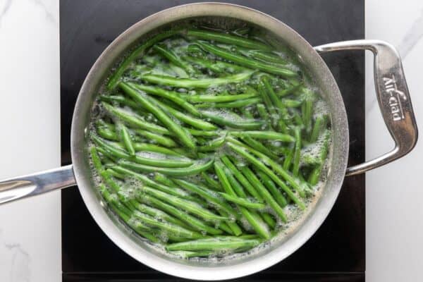 whole green beans cooking in boiling water.