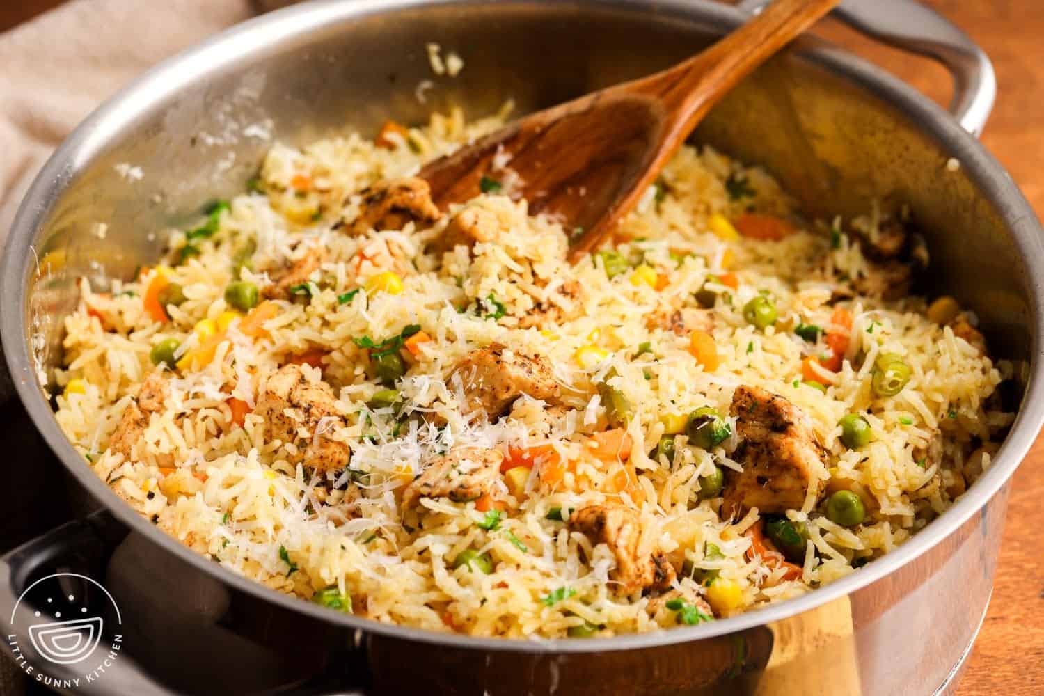 closeup of one pot chicken and rice with mixed vegetables and parmesan cheese.