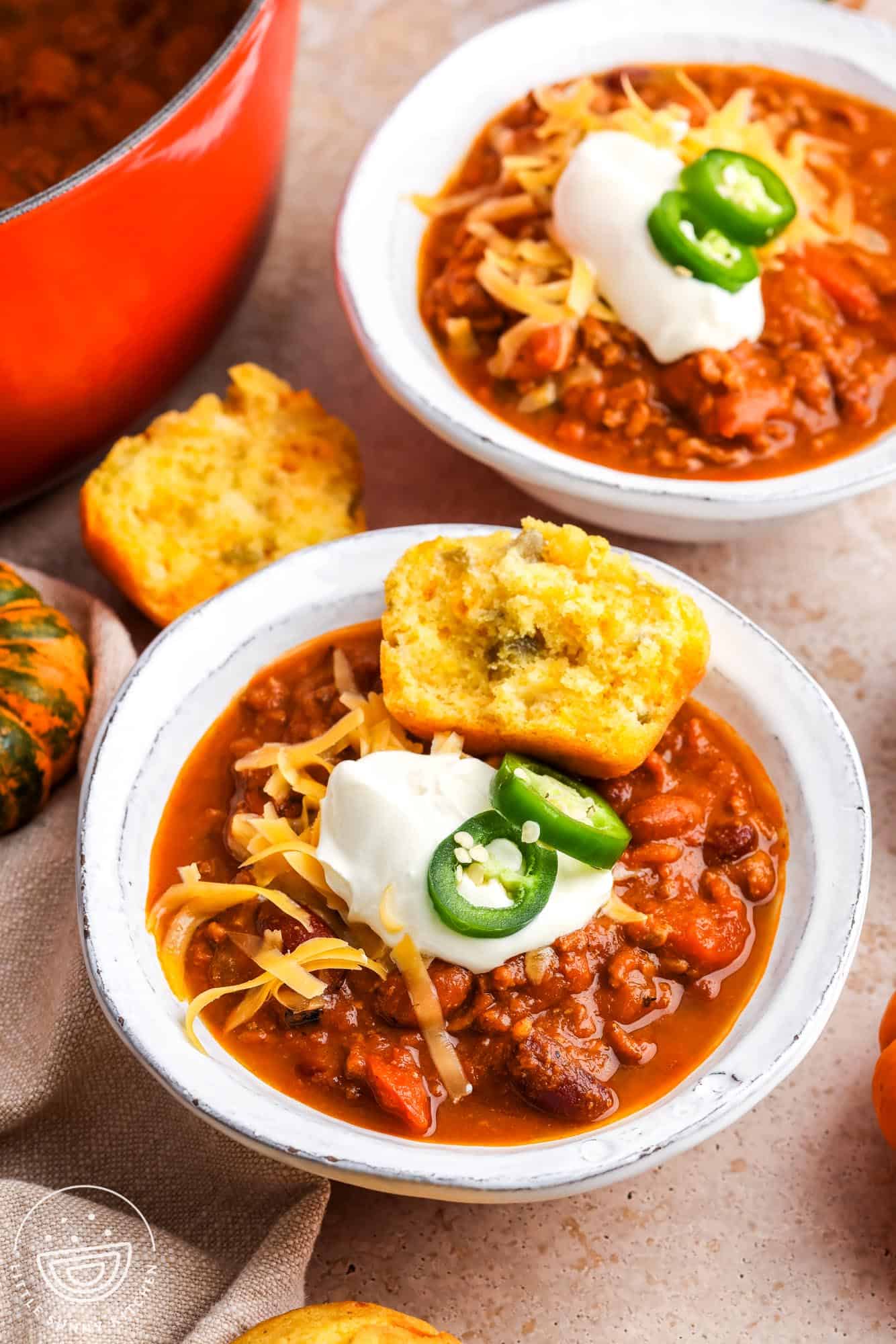 two bowls of pumpkin chili served with jalapeno corn bread.