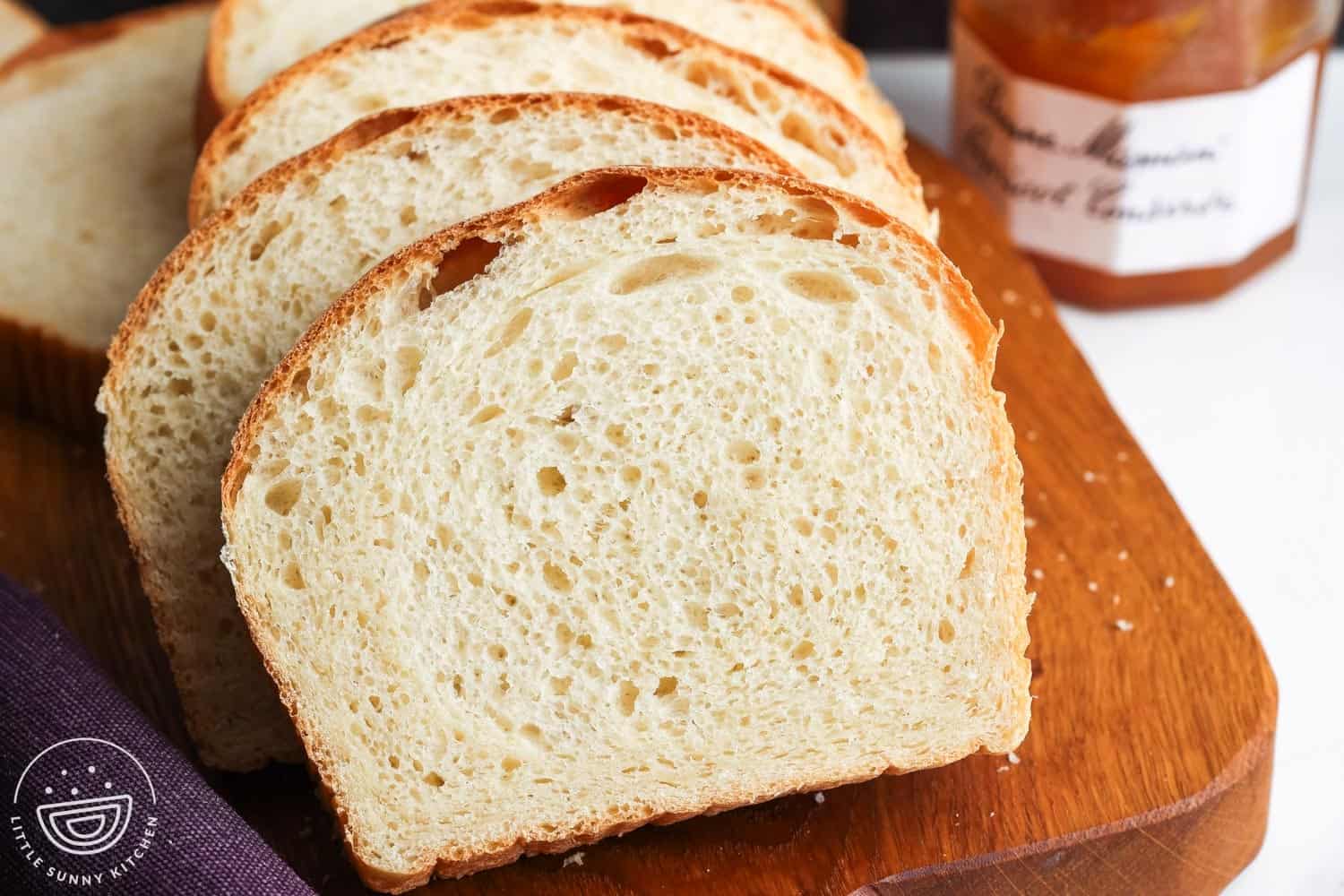 Sliced of soft white sandwich bread, sliced on a wooden board