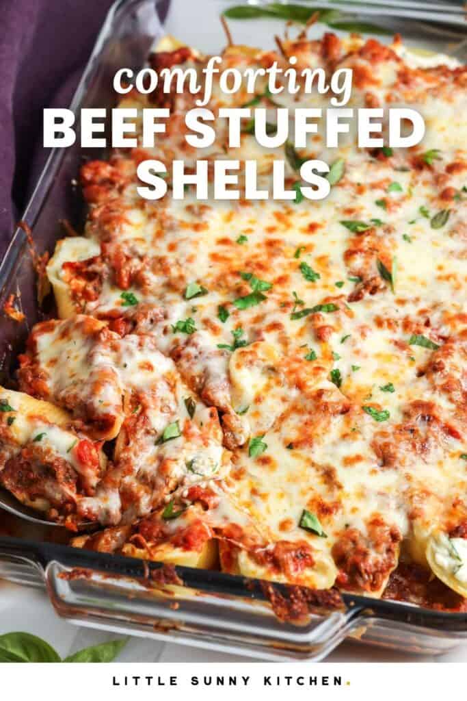 beef filled stuffed shells in a glass baking dish. The text overlayed on the image says "comforting beef stuffed shells"
