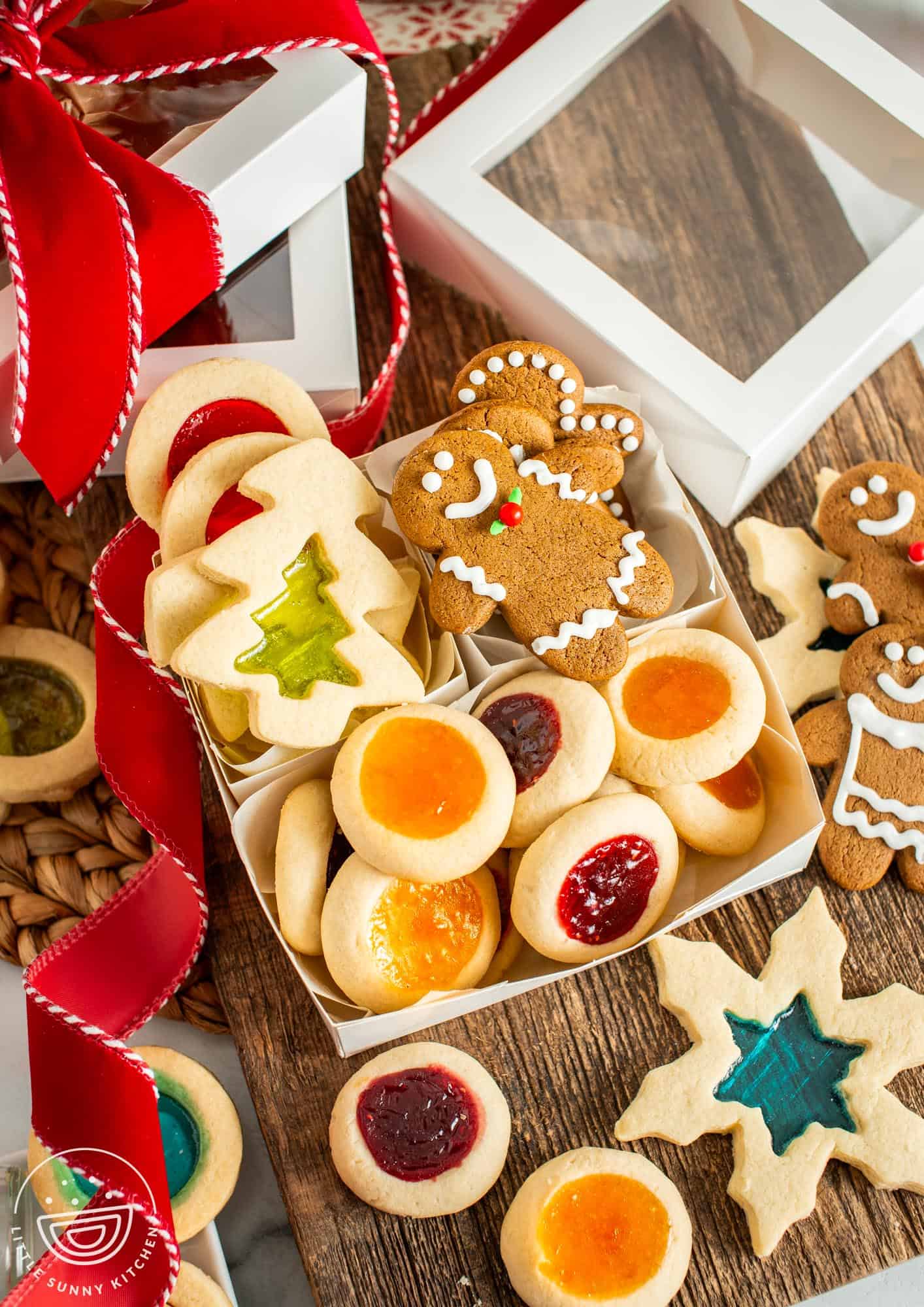 gift box with windowpane cookies, gingerbread men, and thumbprint cookies