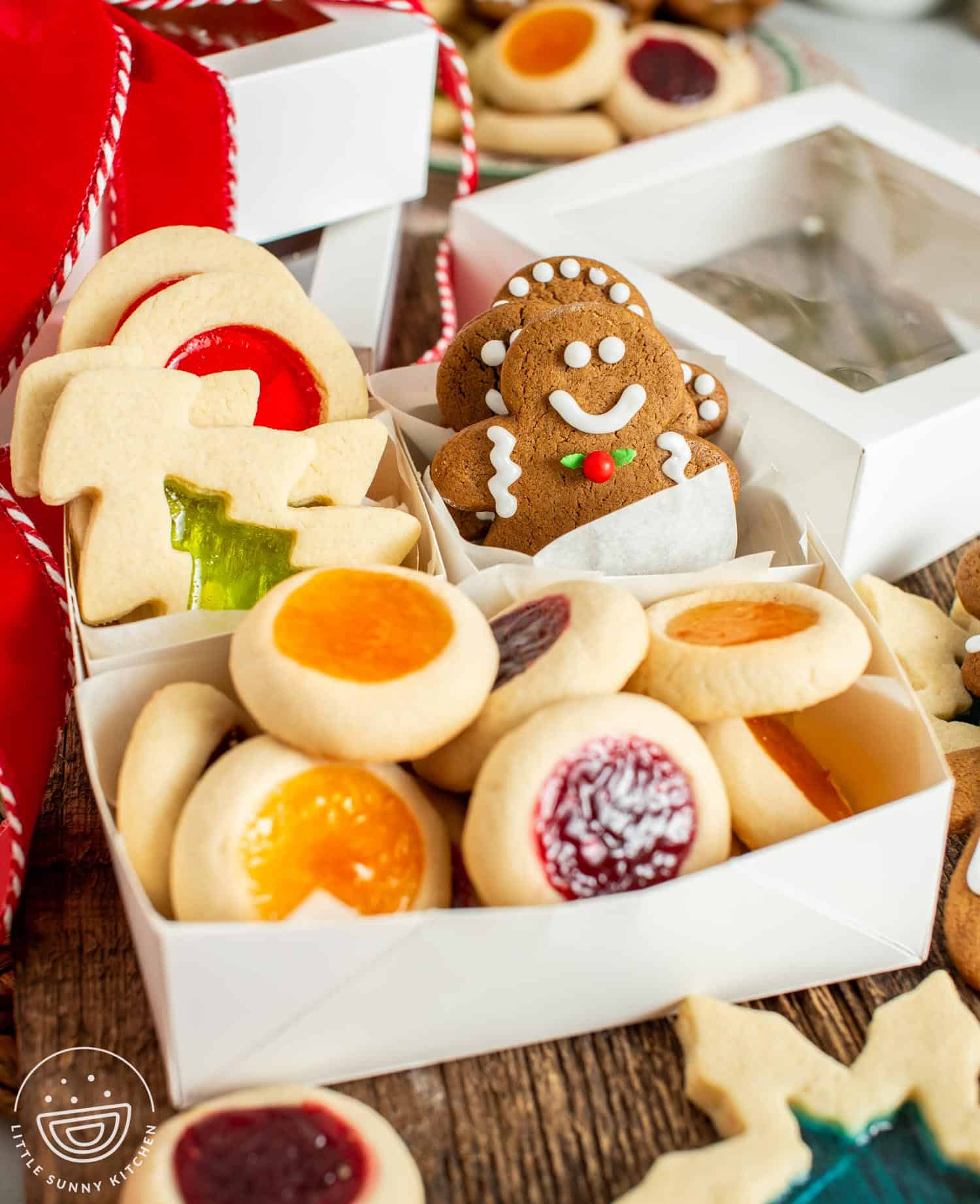 gift box with windowpane cookies, gingerbread men, and thumbprint cookies