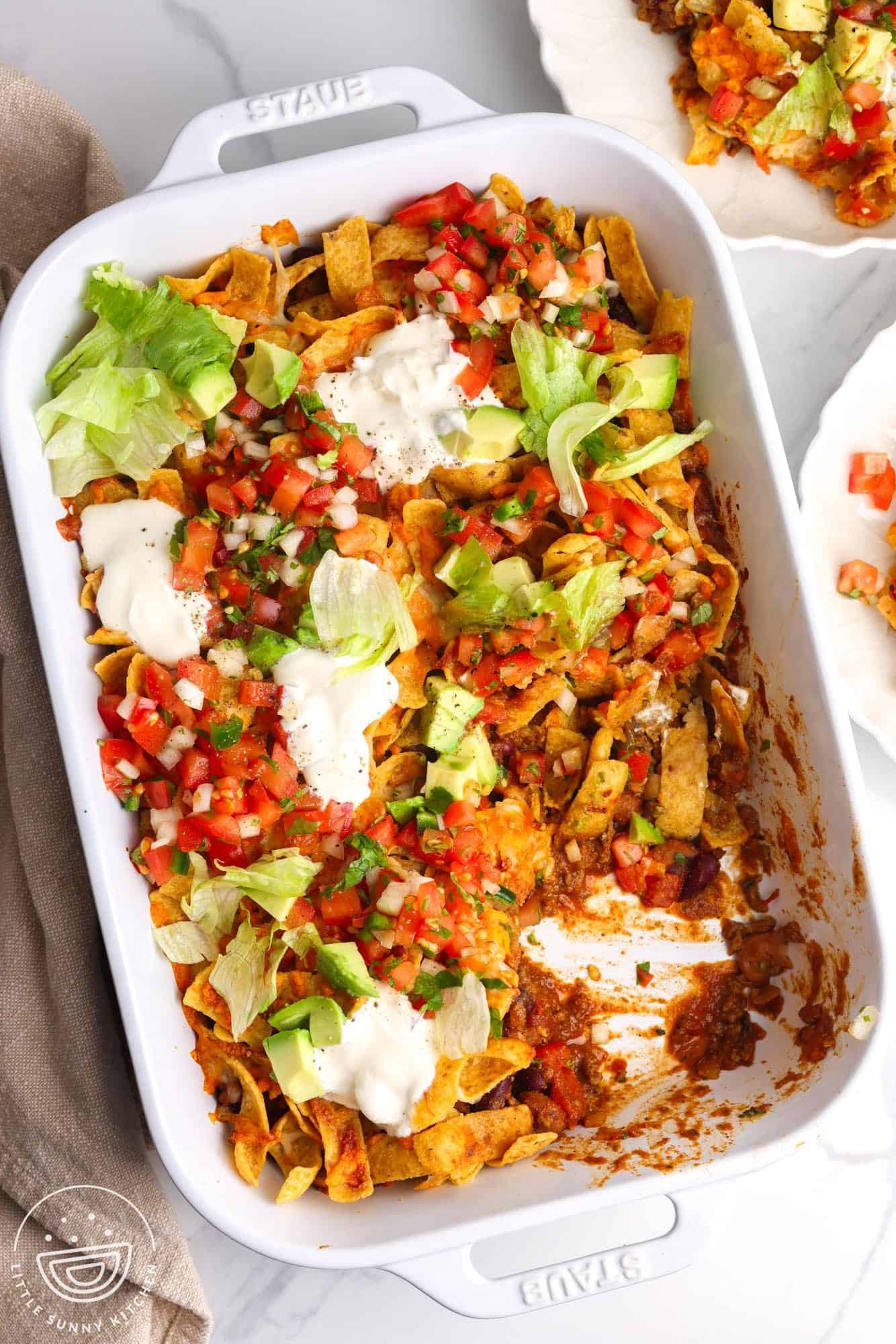 overhead view of a 9x13-inch white casserole dish filled with Frito Pie.