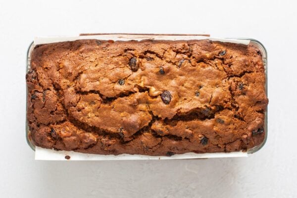 Overhead view of a baked fruitcake in a glass pan that was lined with parchment paper.