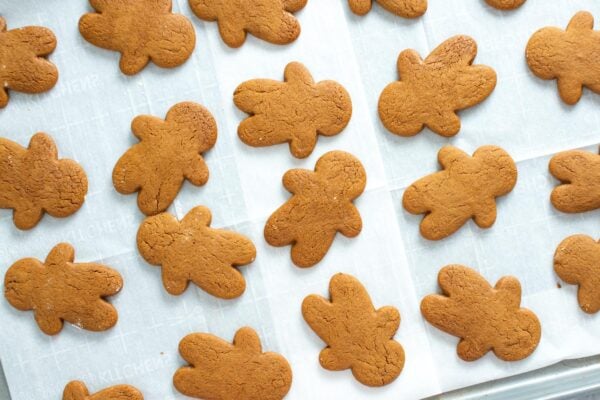 baked gingerbread men on parchment paper.