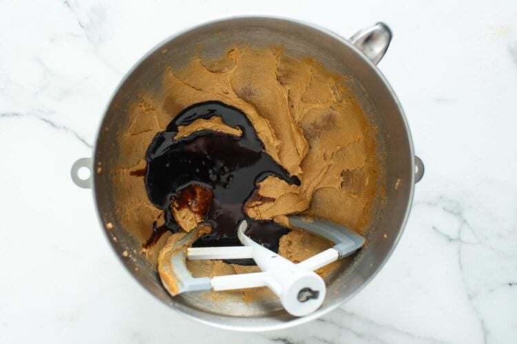 molasses added to creamed butter and brown sugar in a stand mixer bowl.