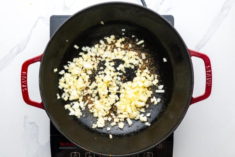 diced onion cooking in a skillet.