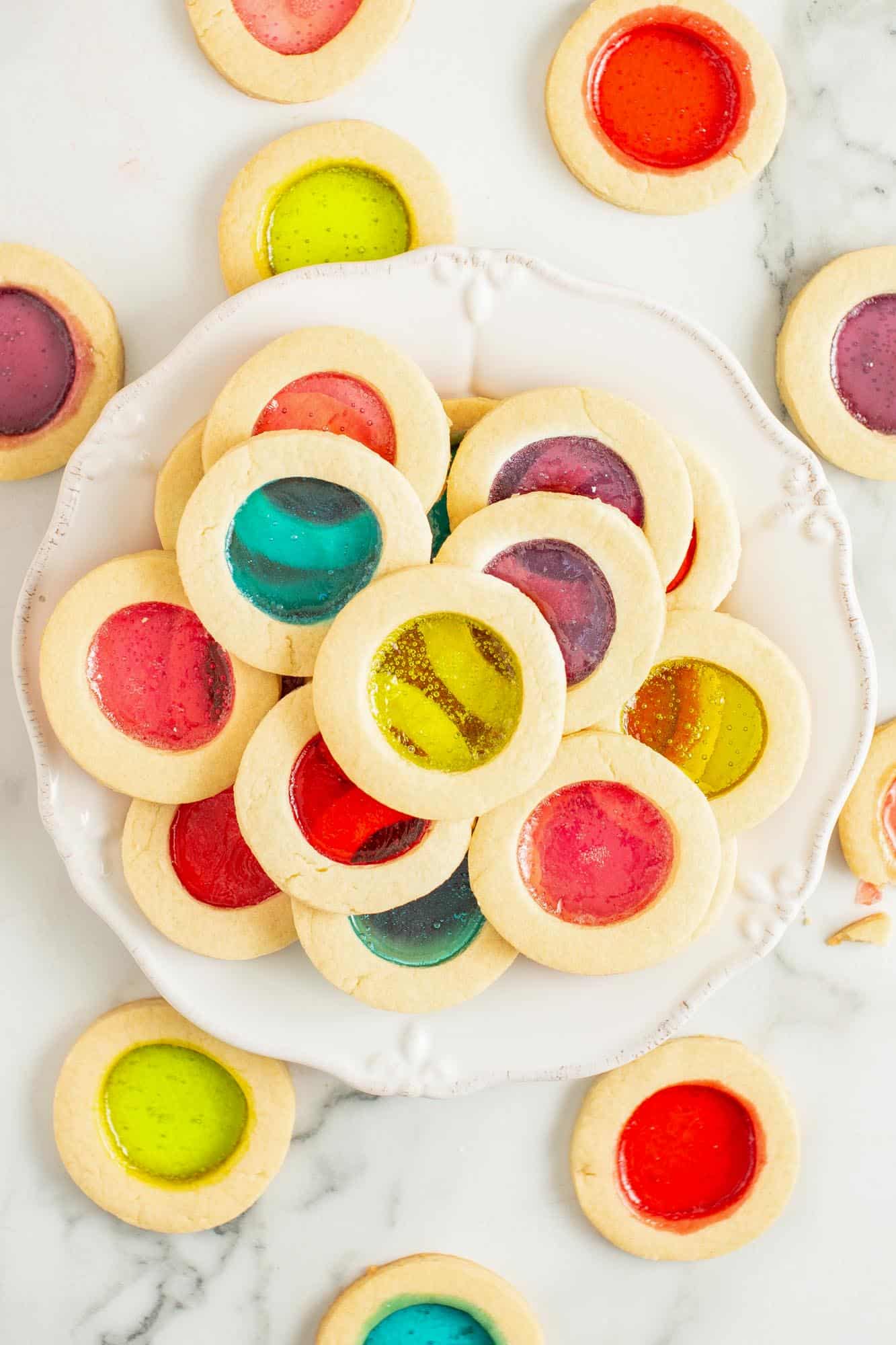 overhead view of a round platter of colorful stained glass christmas cookies.