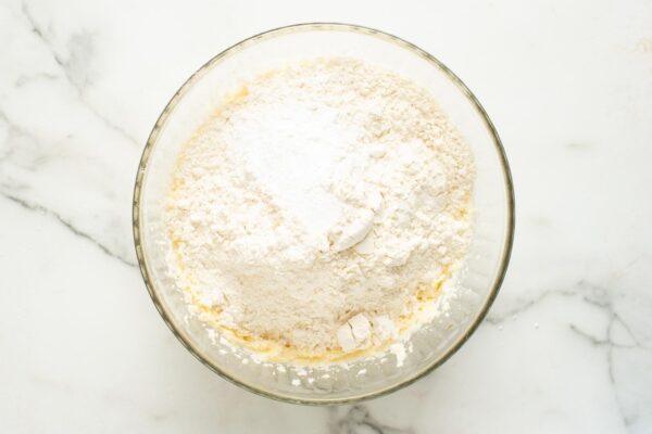 flour added to butter and sugar mixture to make cookie dough.