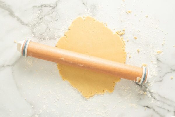 sugar cookie dough rolled flat with a wooden rolling pin.