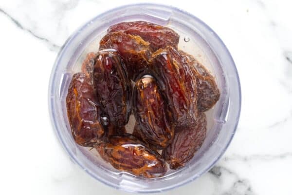 whole dates soaking in boiling water in a bowl.
