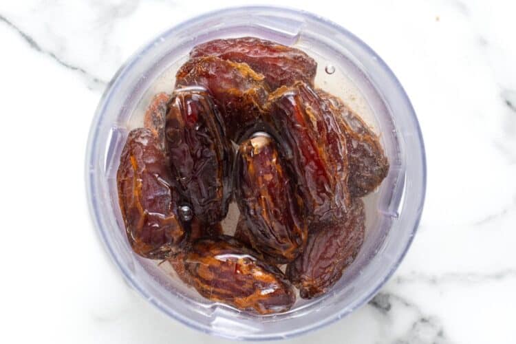 whole dates soaking in boiling water in a bowl.