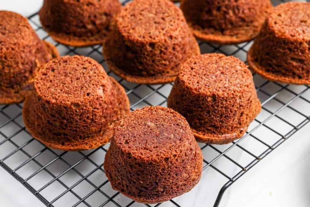 sticky toffee pudding cakes turned upside down, cooling on a wire rack.