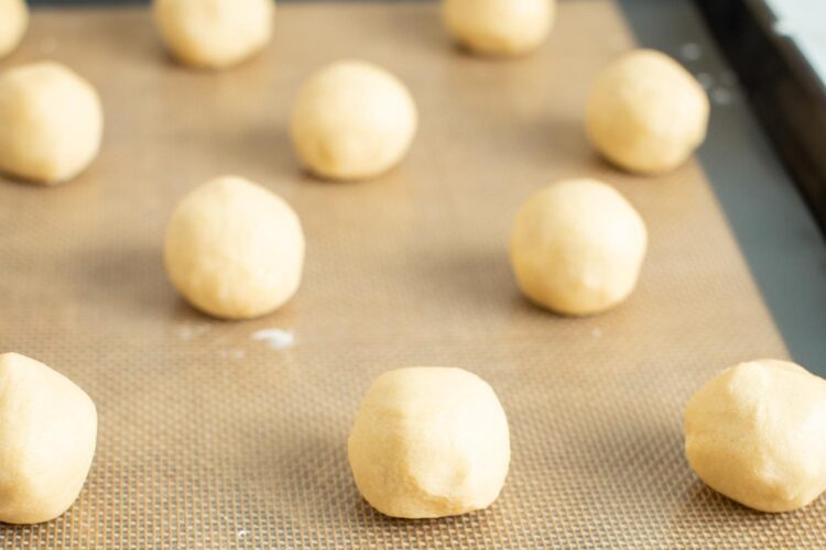 thumbprint cookie dough, rolled into balls, placed on a silpat baking mat.