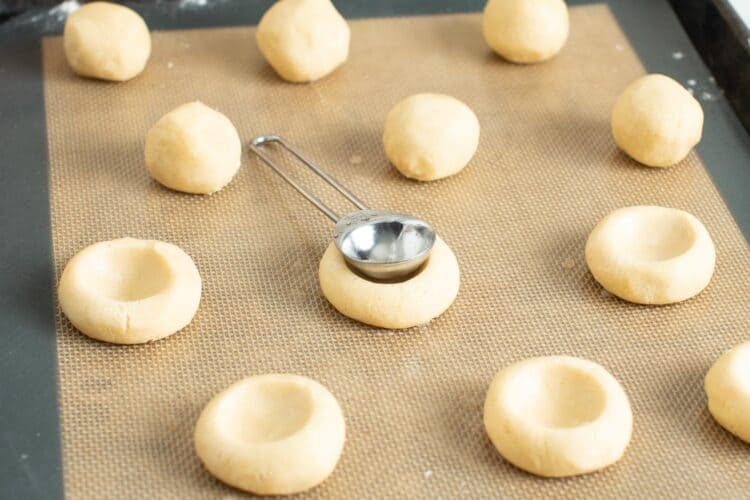 dimples made in thumbprint cookies with the back of a measuring spoon.