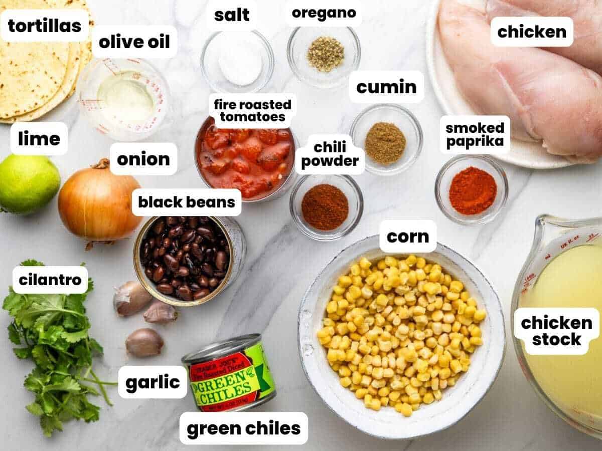 Ingredients needed to make homemade chicken tortilla soup, including black beans, fire roasted tomatoes, and corn tortillas.