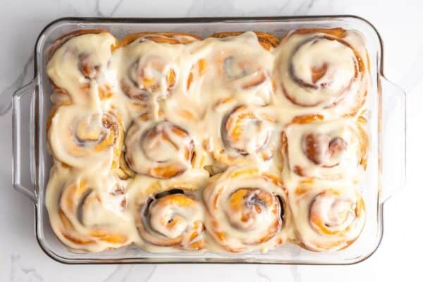 overhead view of a pan of twelve bread machine cinnamon rolls set on a marble counter.